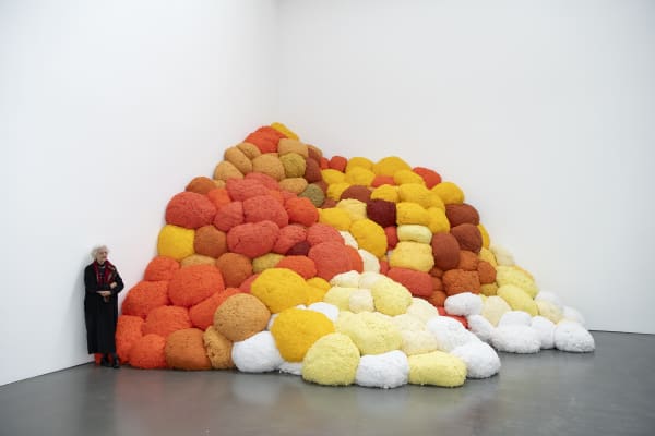 Sheila Hicks neben ihrer Arbeit / Sheila Hicks standing next to her work Saffron Sentinel, 2017 Eingefärbte Fasern/Pigmented fibers Courtesy die Künstlerin/the artist © VG Bild-Kunst, Bonn 2024 Foto / Photo: Katja Illner