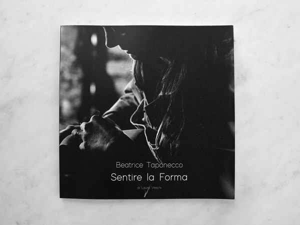 Cover of the book Sentire la Forma by Beatrice Taponecco, featuring a black-and-white photograph of the artist’s hands working on a sculpture. Photo by Laura Veschi.
