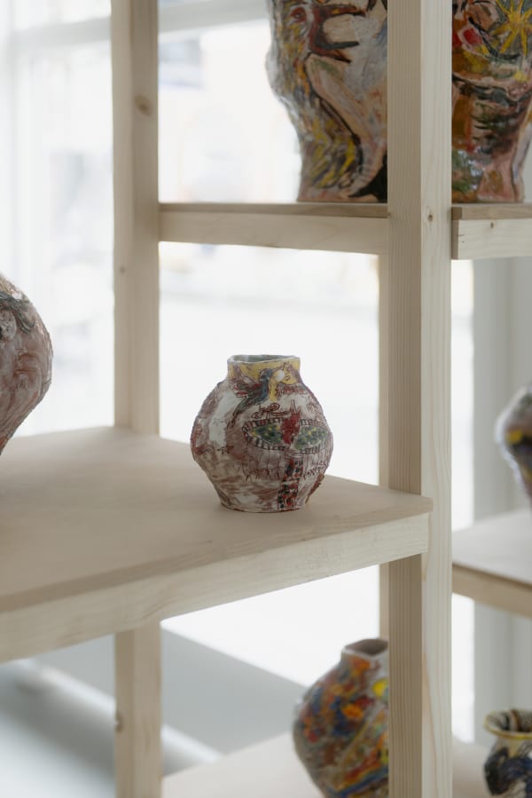 Detail of an installation from Karim Boumjimar’s Mouths, Vessels, Portals (2025), combining chalk drawings on canvas with ceramic forms.