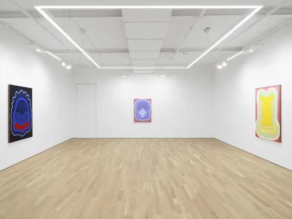 Three abstract paintings in an art gallery with white walls and a wood floor