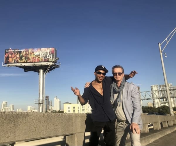 Wardell Milan and David Nolan with Milan's billboard in Miami