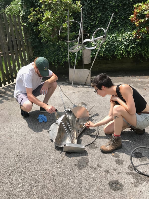 Waxing the sculptures to seal finish.