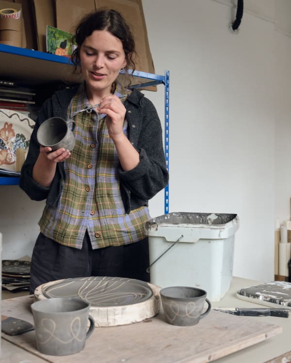 Ali paints the handles of her slipware coffee cups