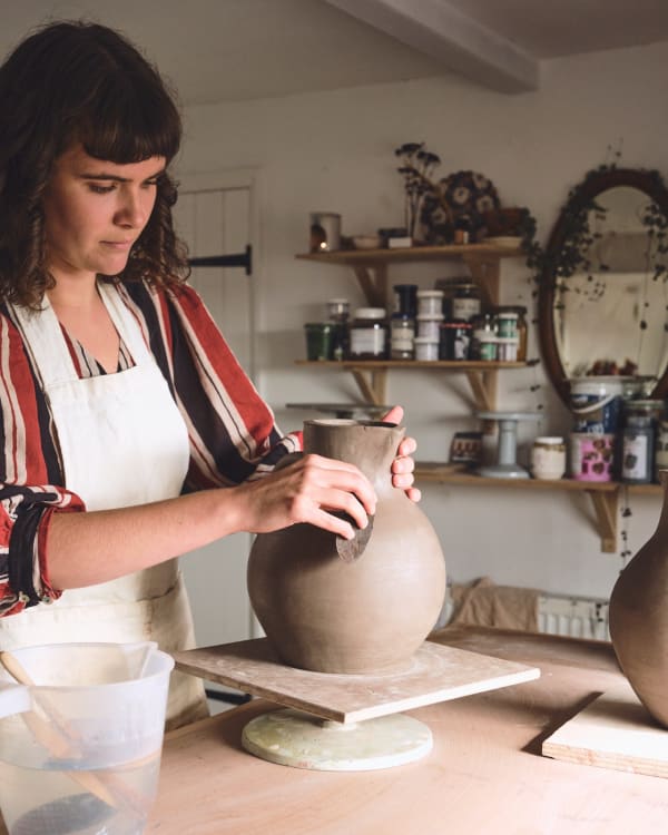 Traditional Bideford jugs use a honey glaze with sgraffito of suns and flowers