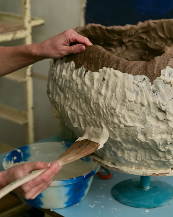 Porcelain is applied to stoneware to whitewash the pieces
