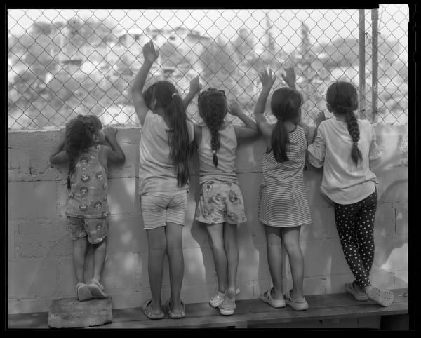 Lisa Elmaleh, Five girls watching life outside of the shelter, House of Mercy, Nogales, Sonora, Mexico; Cinco niñas viendo la vida fuera del Albegue, Casa de la Misericordia, Nogales, Sonora, México, 2024