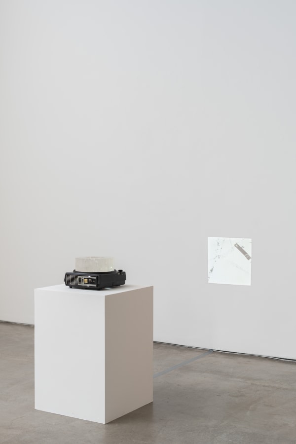 Gabriel Sierra Recalque, 2015 - 2025 projetor de slides, quartzo e mesa dobrável de metal [slide projector, quartz and metal folding table] dimensões variáveis [variable dimensions]