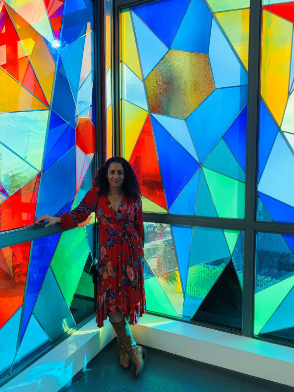 Artist Adia Millett in front of the artwork