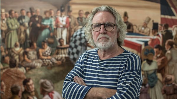Artist Dick Frizzell standing in front of one of his paintings