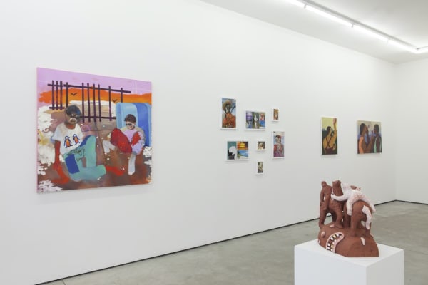 Installation view of "Buscando Recuerdos" group exhibition, ceramic sculpture on pedestal in foreground and colorful paintings by various artists hang on wall in background