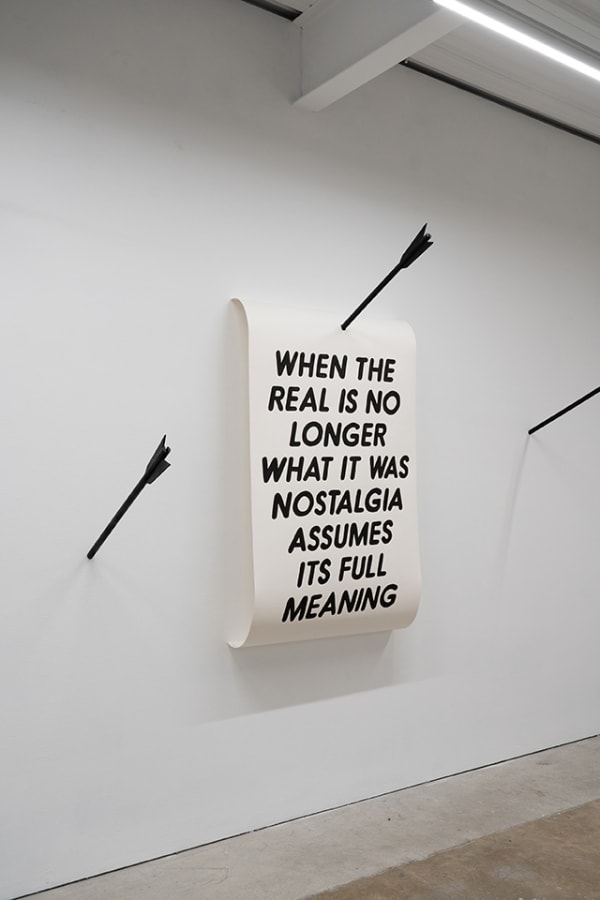 text artwork hung on white wall