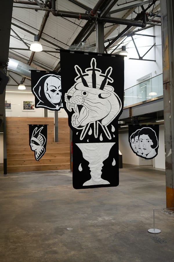black and white embroided banners hung in the atrium of Minnesota Street Projects