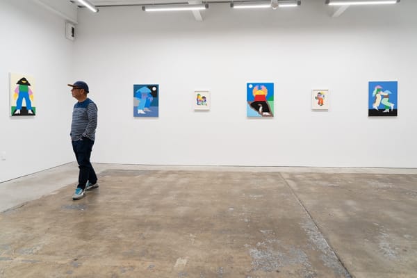 Installation view of Marbie's solo show "Good Love is Hard to Find," where images of abstracted figures, rendered in bright, color blocked hues, pose in various positions. A man on the left side of the photo stops to look at four small collages.