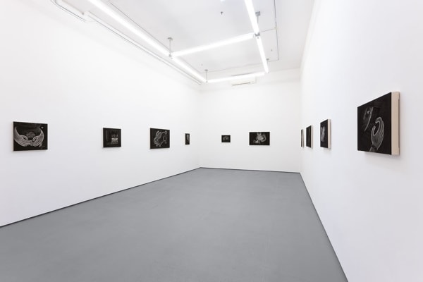 Installation view of Angela Fang Zirbes exhibition "House & Ghosts" featuring greyscale paintings on three white walls
