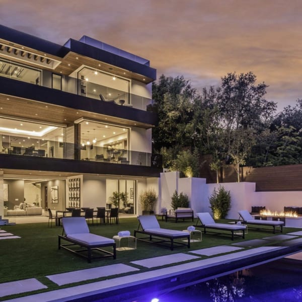 exterior shot of large glass house; in ground pool is visible