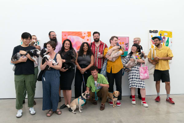 artists and Hashimoto Contemporary staff hold dogs in a white cube gallery in front of paintings