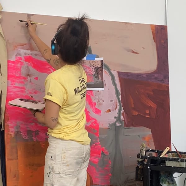 Photograph of artist Seonna Hong in her studio painting
