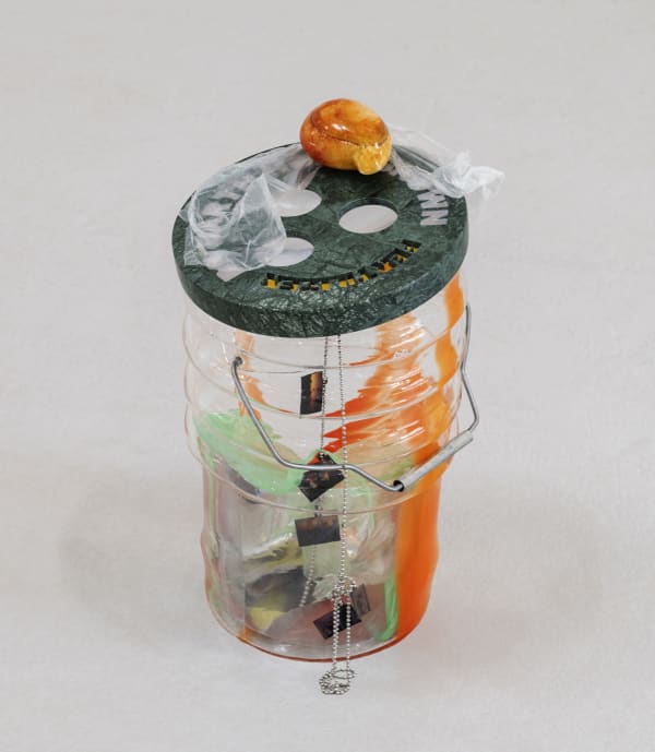 Catherine Telford Keogh Dust Gardens (Germination), 2025 Mold-blown glass (Leaktite™ 2-gallon white plastic pail), found plastic bag, magnifying sheets, waterjet-cut green marble, hand-carved orange onyx, stained glass, nickel-plated chain, found slides of sunsets, and halloween costumes, plastic bag, Jell-O® mold, inherited sulphur butterfly, steel rod, stainless steel drink straw, household dust 19 x 10¼ x 10¼ inches 48.3 x 26 x 26 cm