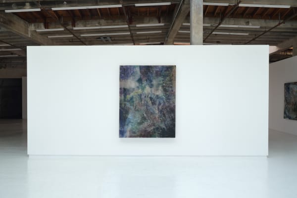 An installation image of the exhibition. An abstract painting hung on a white wall in a large gallery space.