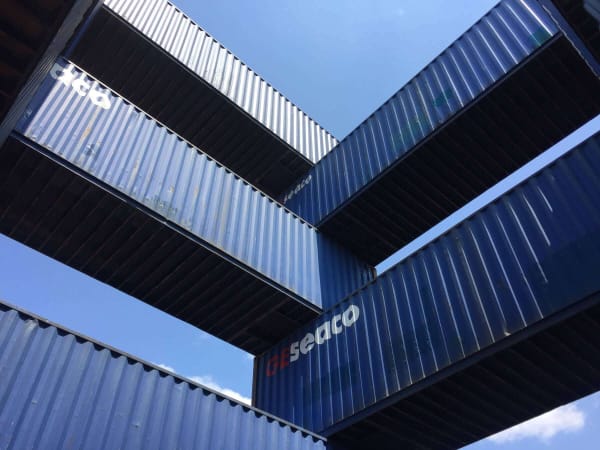 Blue shipping containers stacked at the corners