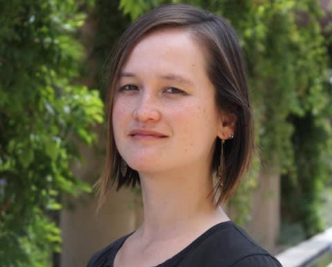 Headshot of a brunette woman in front of trees.