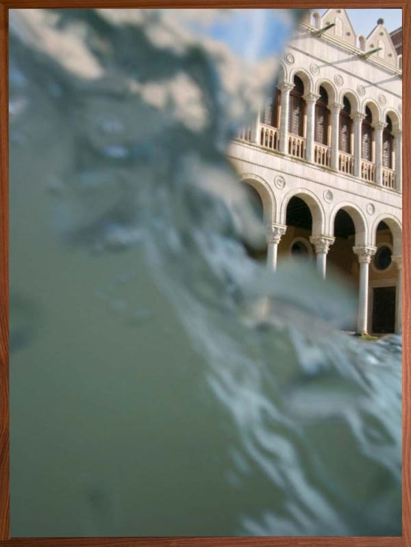 Venice from the canal, wave of water on left side of frame, with white sunshine lit palazzo on top right side, perfect venetian arches, by Mona Kuhn