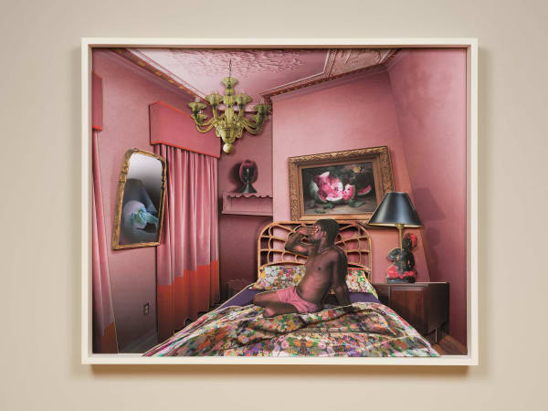 man covering his eyes in front of mirror in pink interior by Ron Norsworthy