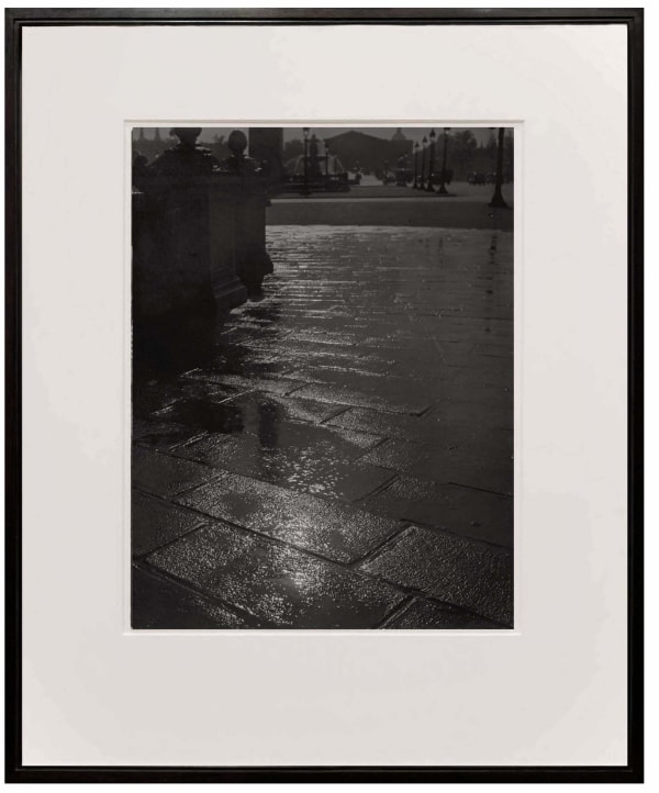 framed photograph of light reflection on rainy street at Place de la Concorde from Paris de Nuit by Brassai