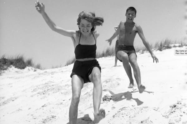 Lillian Bassman photograph of Richard Avedon and his wife Doe running on beach in bathing suits