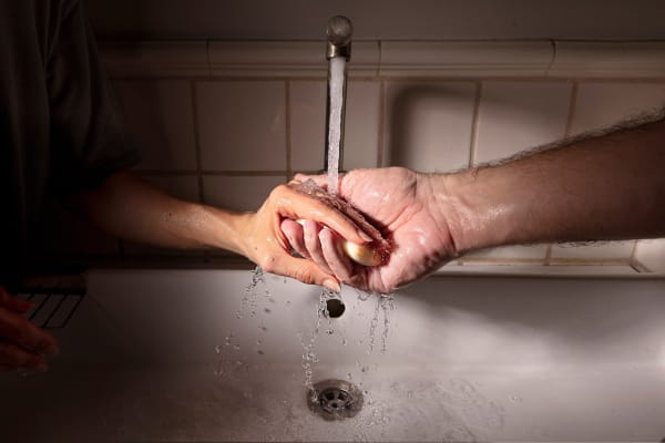 Elinor Carucci photograph of hands holding soap over the sink