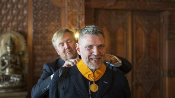 the King of The Netherlands places Medal of Honor around the neck of artist Erwin Olaf