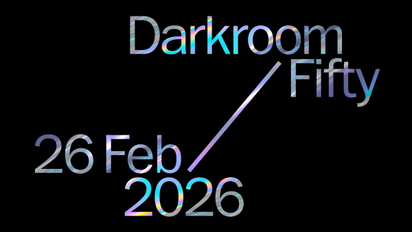 Iridescent text on a black background reads “Darkroom Fifty” and “26 Feb 2026,” arranged diagonally in a clean, modern graphic design.