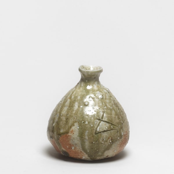 Shiro Tsujimura #000667 Sakeflasche (tokkuri), 1992 Graubraun gebranntes, helles Steinzeug; glänzendweiße Quarzeinschlüsse; natürliche Aschenglasur (shizenyû); Glasurtropfen am unteren Rand. Signiert: geritztes Zeichen für Ofen (“kama”). Holzkasten mit Aufschrift “Tokkuri”; signiert: Tsujimura Shirô; Siegel: Shirô 14,1 x 12,5 cm