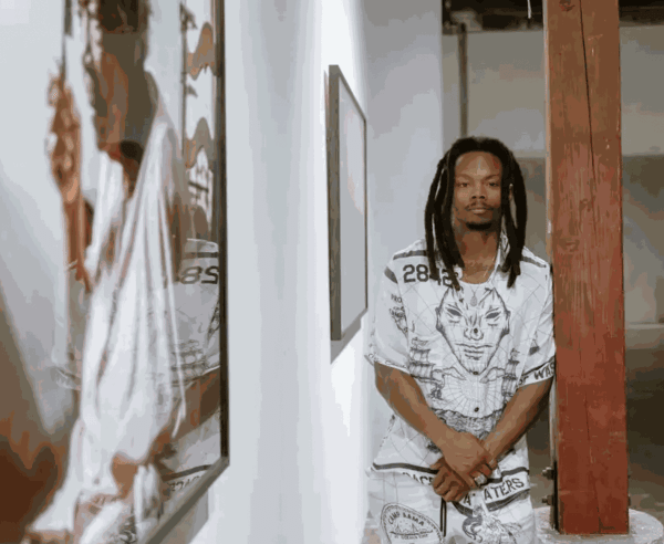 Adrian L. Burrell poses with his exhibition “Venus Blues” at the Minnesota Street Project Foundation in the Dogpatch district in San Francisco.