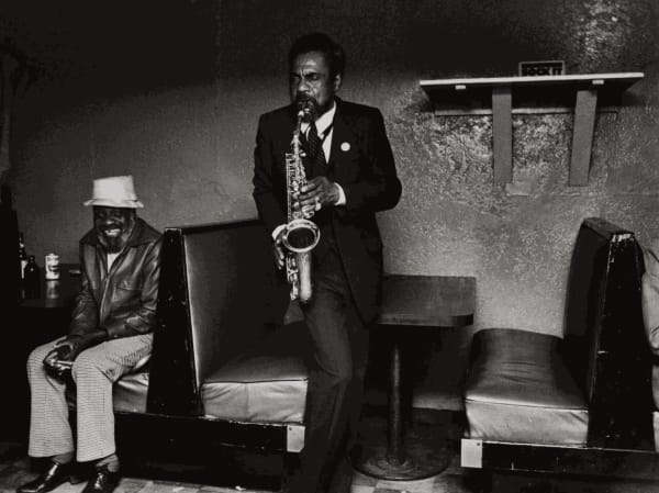 One of the images on display at Black Spaces: Reclaim & Remain: Michelle Vignes, Kenny Playing Sax at the De Luxe Inn in Oakland, 1983. Credit: Collection of the Oakland Museum of California. Michelle Vignes photograph archive, © The Regents of the University of California, The Bancroft Library, UC Berkeley.