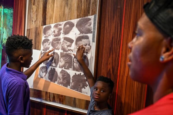 Brothers Zyshaun Knox, 10, and Nasir Blake, 7, point to their choices of haircut styles, debating the merits of each with barber Brixton Millner. (Jahi Chikwendiu/The Washington Post)