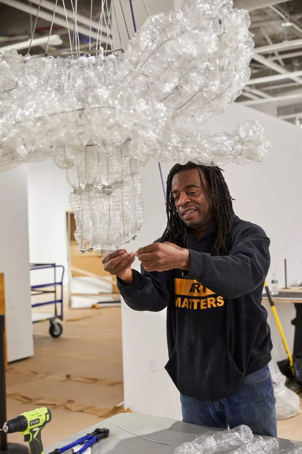 Willie Cole in his artist-in-residence studio at Express Newark, where he has been assembling chandeliers made from thousands of used plastic bottles.