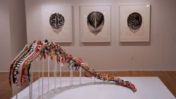 This sculpture is made in the same shape of an ascending 200-meter track upon which Flo-Jo set the world record in the 1988 Olympics, according to artist Pamela Council, who created the piece. The paintings in the back are by So Yoon Lym. Courtesy of Pamela Council