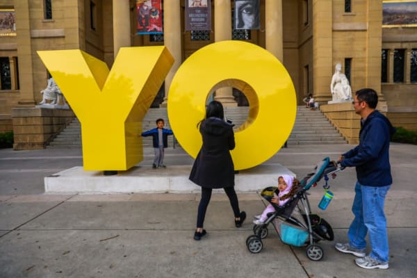 Gavin Gong, 4 (left) poses for a photo on Deborah Kass’ “Oy/Yo” sculpture outside the Cantor Arts Center in Palo Alto. Photo: Gabrielle Lurie / The Chronicle