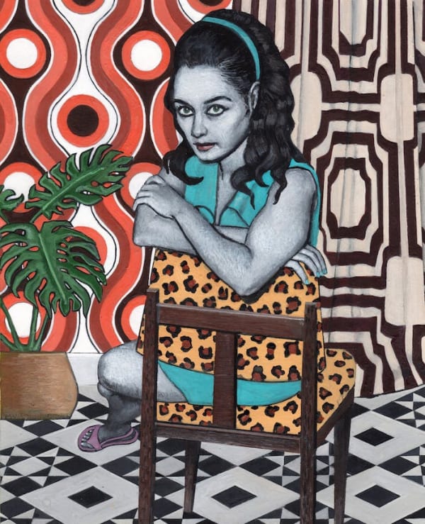 Portrait of Katayoun. Women sitting in backwards chair with cheetah print. Room in background filled with patterns and colours.
