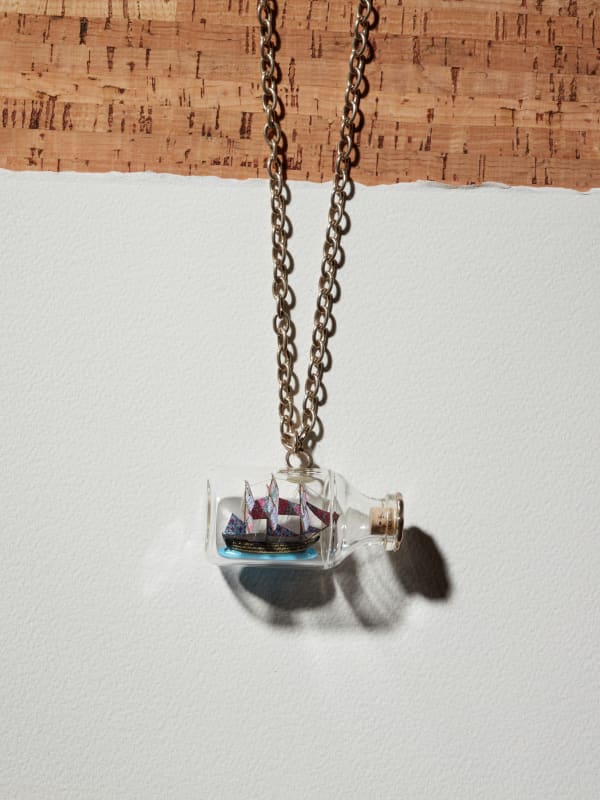 Yinka Shonibare MBE, Ship in a Bottle Pendant, 2011, hand painted resin, glass, wood & silver chain. Incised with the artist's initials, numbered & hallmarked. Bottle: 3.5 x 6.9 x 3.5 cm; 96 g. Plinth: 5.0 x 5.1 x 2.5 cm. Edition of 10 + 4 AP in collaboration with Louisa Guinness.