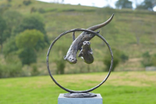 bronze sculpture of two otters swimming