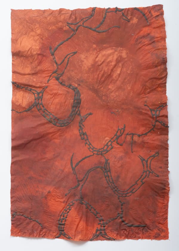 abstract work of homemade paper in rust red, with darker red lines in braided shapes in the foreground