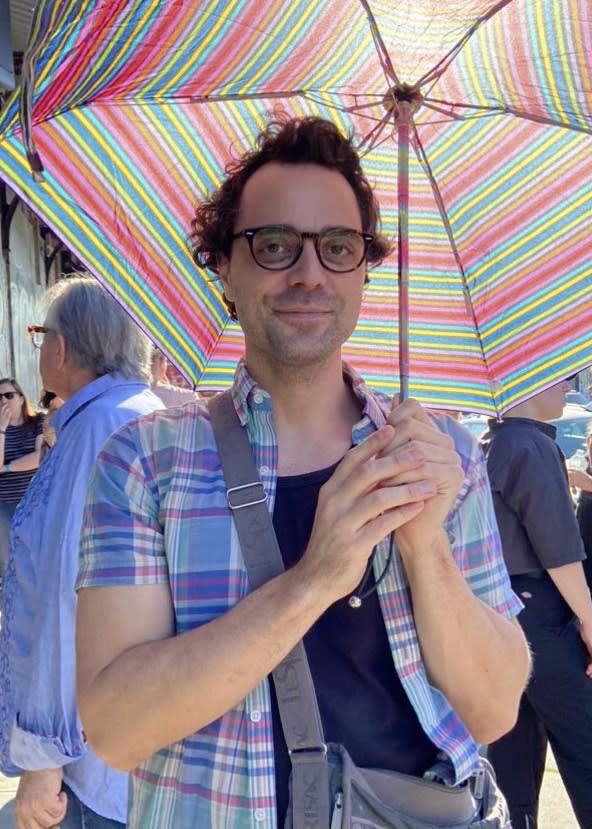 Photo of artist Zuriel Waters holding an umbrella.