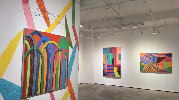 Gallery walls with colorful, geometric abstract paintings and mural by Cynthia Rojas from the exhibition, "Some Wheres I've Been."