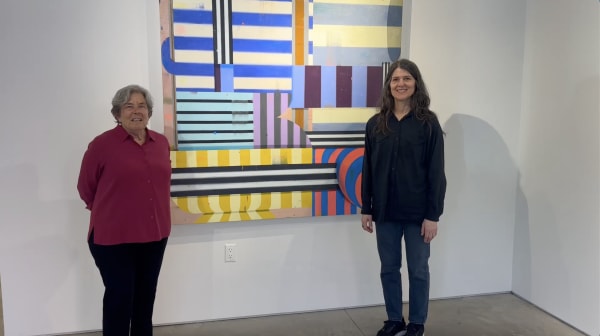 Kathryn Markel and Deborah Zlotsky standing in front of an abstract painting.