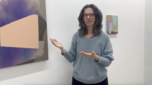 Erin O'Brien standing in front of two of her paintings.