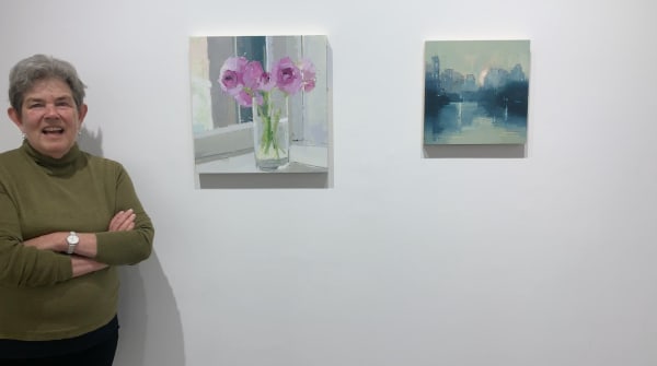Kathryn Markel with two paintings by Lisa Breslow.
