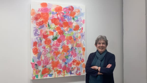 Woman standing next to abstract vibrant art