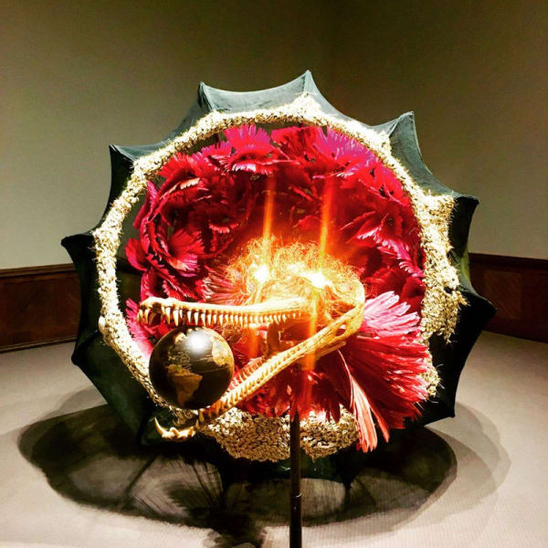 Rina Banerjee The world as burnt fruit - When empires feuded for populations and plantations, buried in colonial and ancient currency a Gharial appeared from an inky melon - hot with blossom sprang forth to swallow the world not yet whole as burnt fruit2009 Fans, feather, cowry shells, resin alligator, skull, globe, glass vials, light bulbs, gourds, steel wire and Japanese mosquito nets, 90 x 253 x 90 inches.